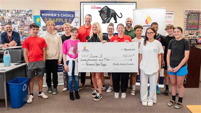  An image of the Chandler Education Foundation Raffle winner smiling with a big check and students